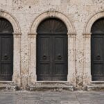 Tre portali in pietra di un edificio pubblico italiano, uno socchiuso, a illustrare le vie di accesso al Conto Termico